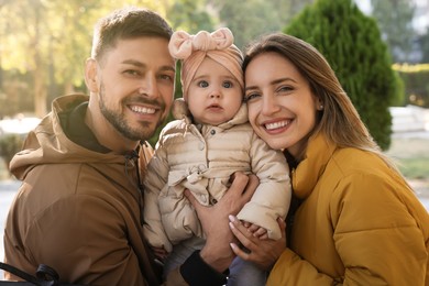 Photo of Happy parents with their baby in park on sunny day