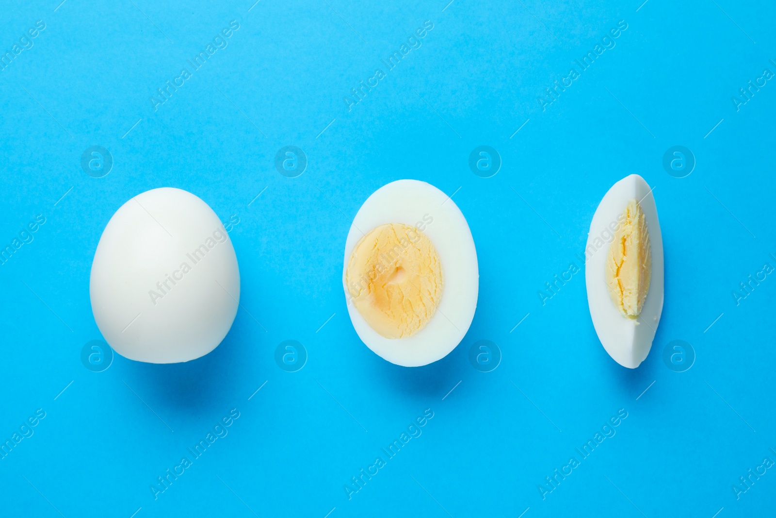 Photo of Fresh hard boiled eggs on light blue background, flat lay