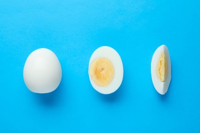 Photo of Fresh hard boiled eggs on light blue background, flat lay