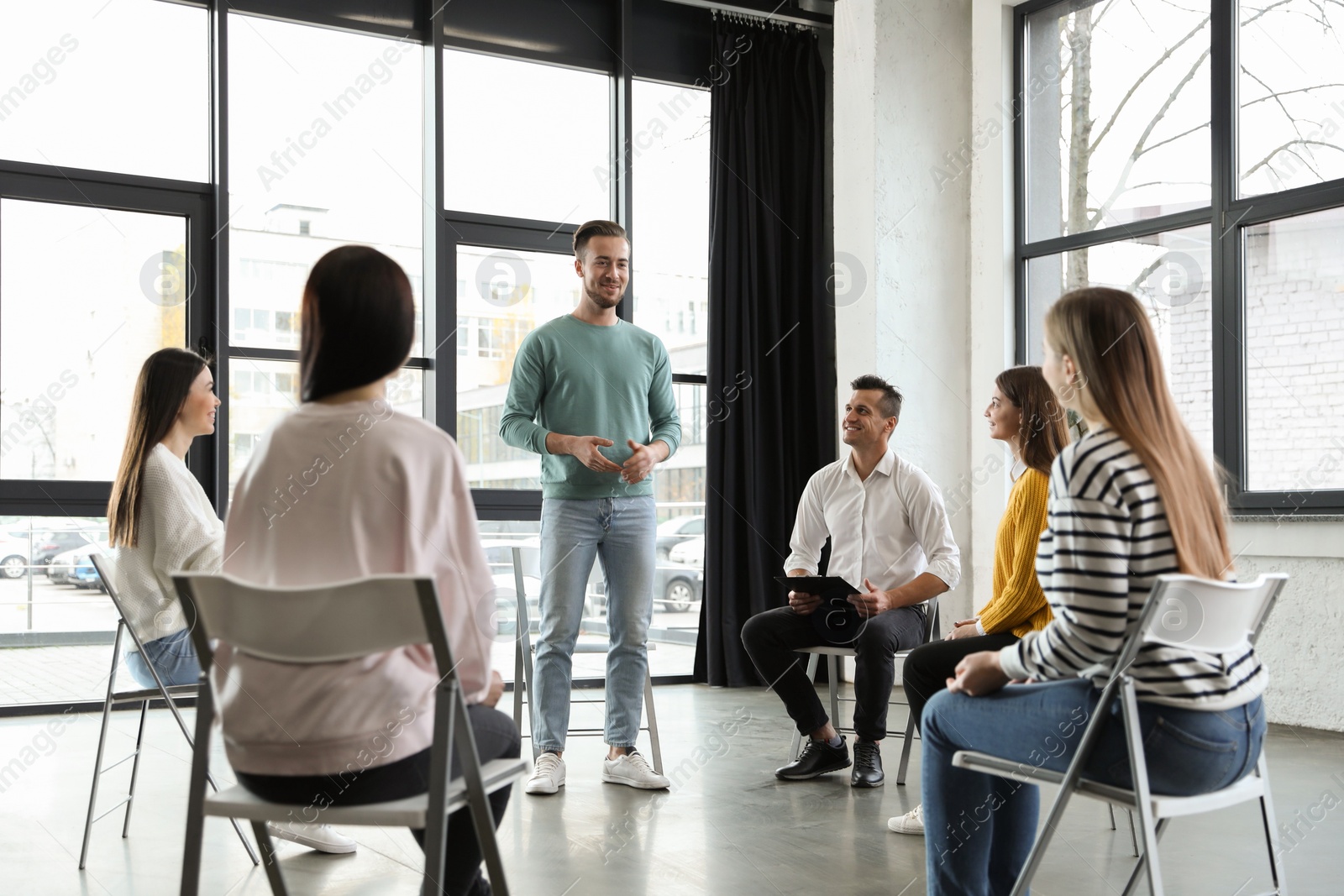 Photo of Psychotherapist working with patients in group therapy session indoors