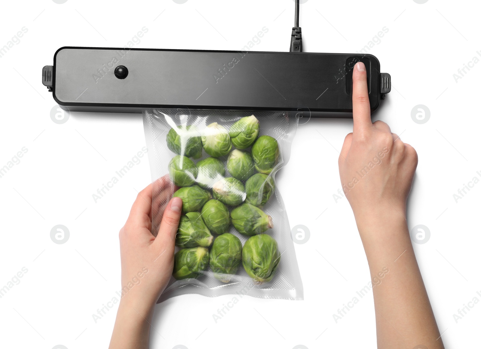 Photo of Woman using sealer for vacuum packing of Brussels sprouts on white background, top view