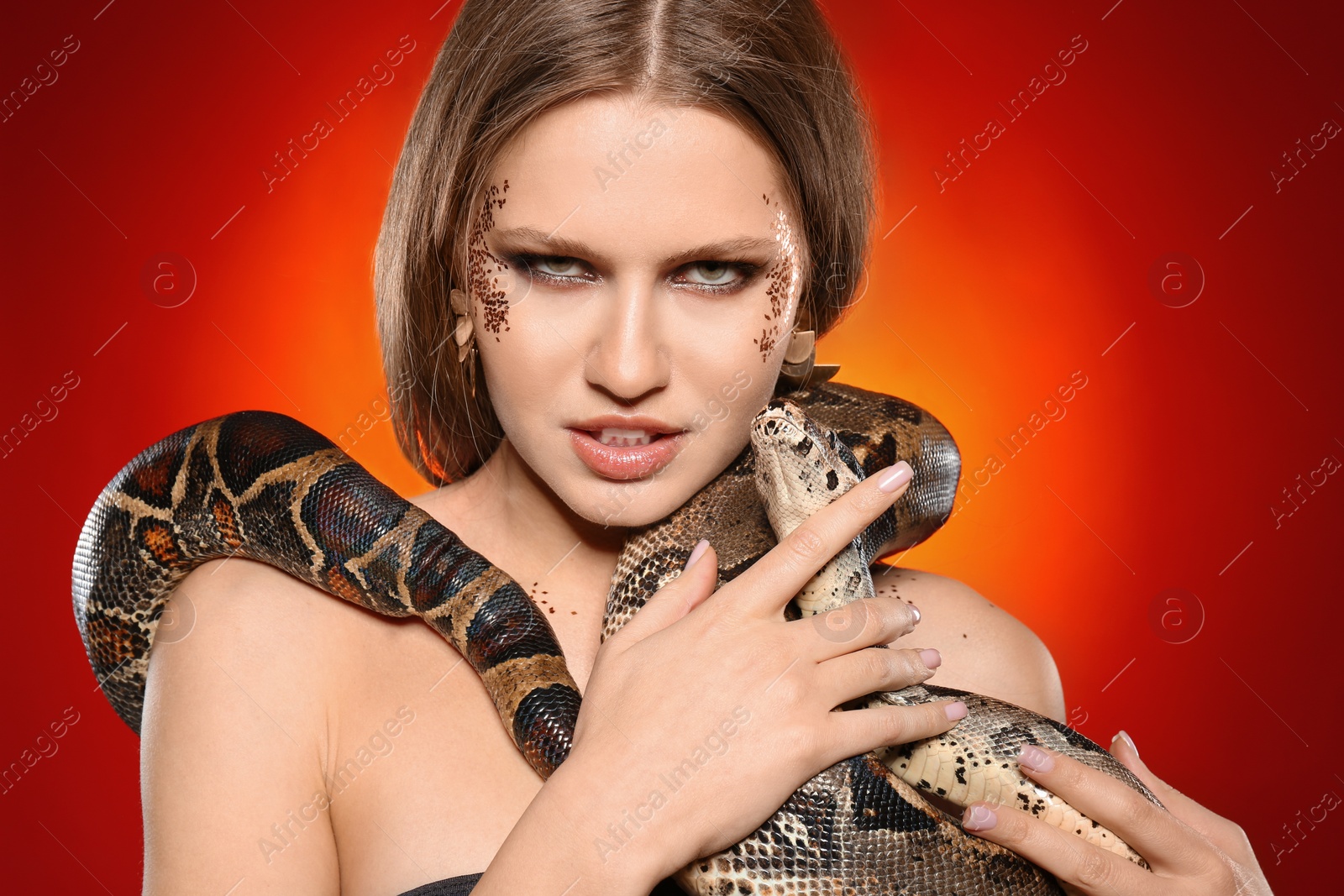 Photo of Beautiful woman with boa constrictor on bright colorful  background