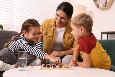 Photo of Family playing checkers at coffee table in room