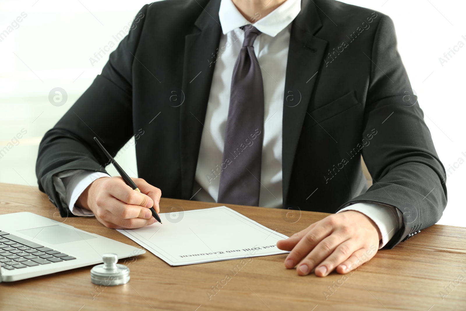 Photo of Male notary working with documents at wooden table, closeup