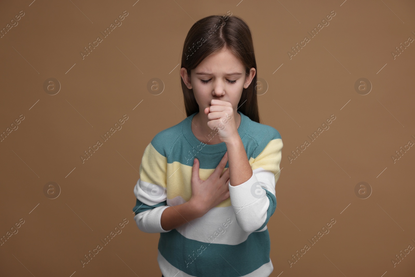 Photo of Sick girl coughing on brown background. Cold symptoms