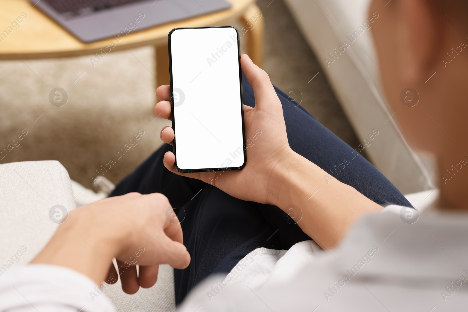 Photo of Man using smartphone with blank screen indoors, closeup. Mockup for design