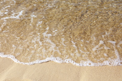 Photo of View of sea water and beach sand on sunny day