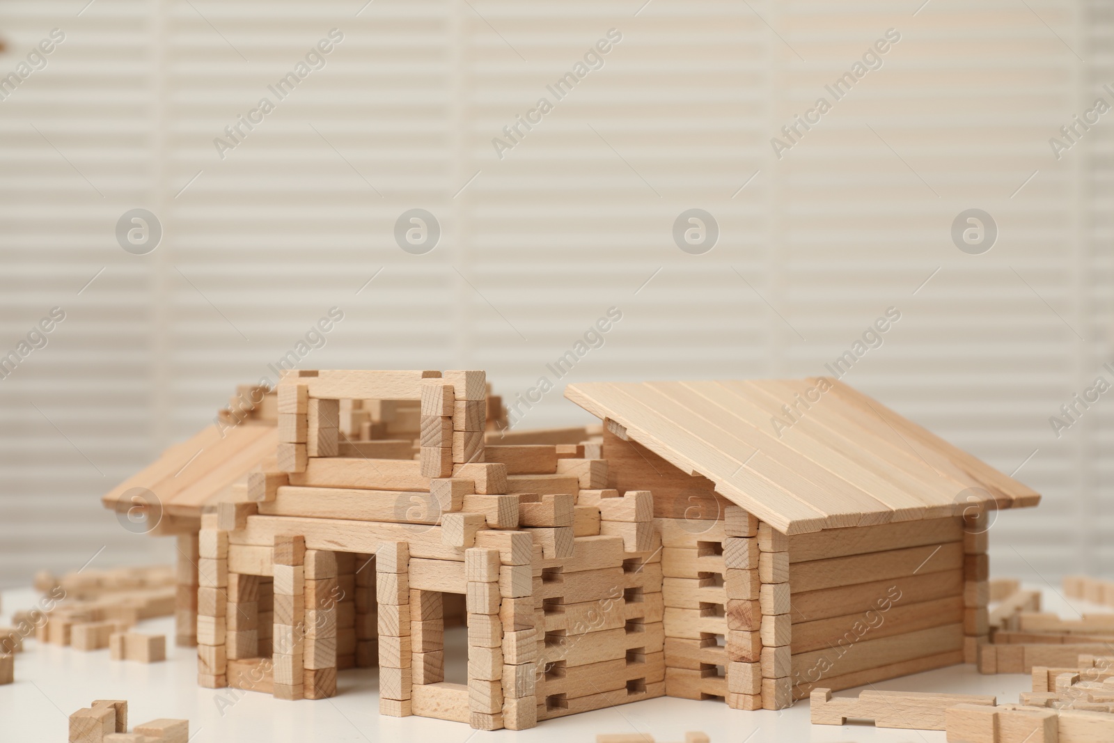 Photo of Wooden construction set on white table, space for text. Children's toy