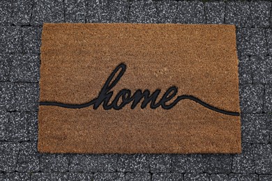 Doormat with word Home on pavement, top view