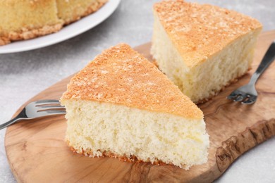 Photo of Pieces of tasty sponge cake on grey table, closeup