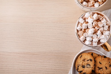 Photo of Hot drink with marshmallows and cookies on wooden table, flat lay. Space for text