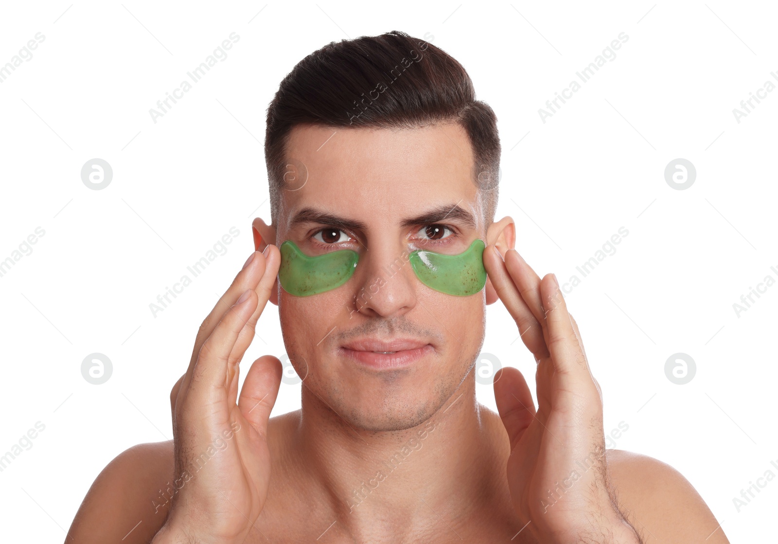 Photo of Man applying green under eye patches on white background