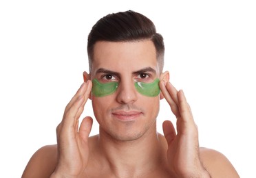 Man applying green under eye patches on white background