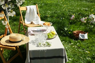 Stylish table setting with beautiful spring flowers in garden on sunny day