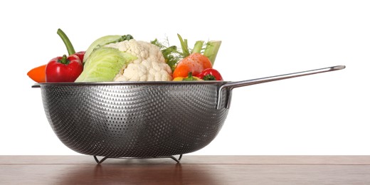 Photo of Metal colander with different vegetables on wooden table against white background