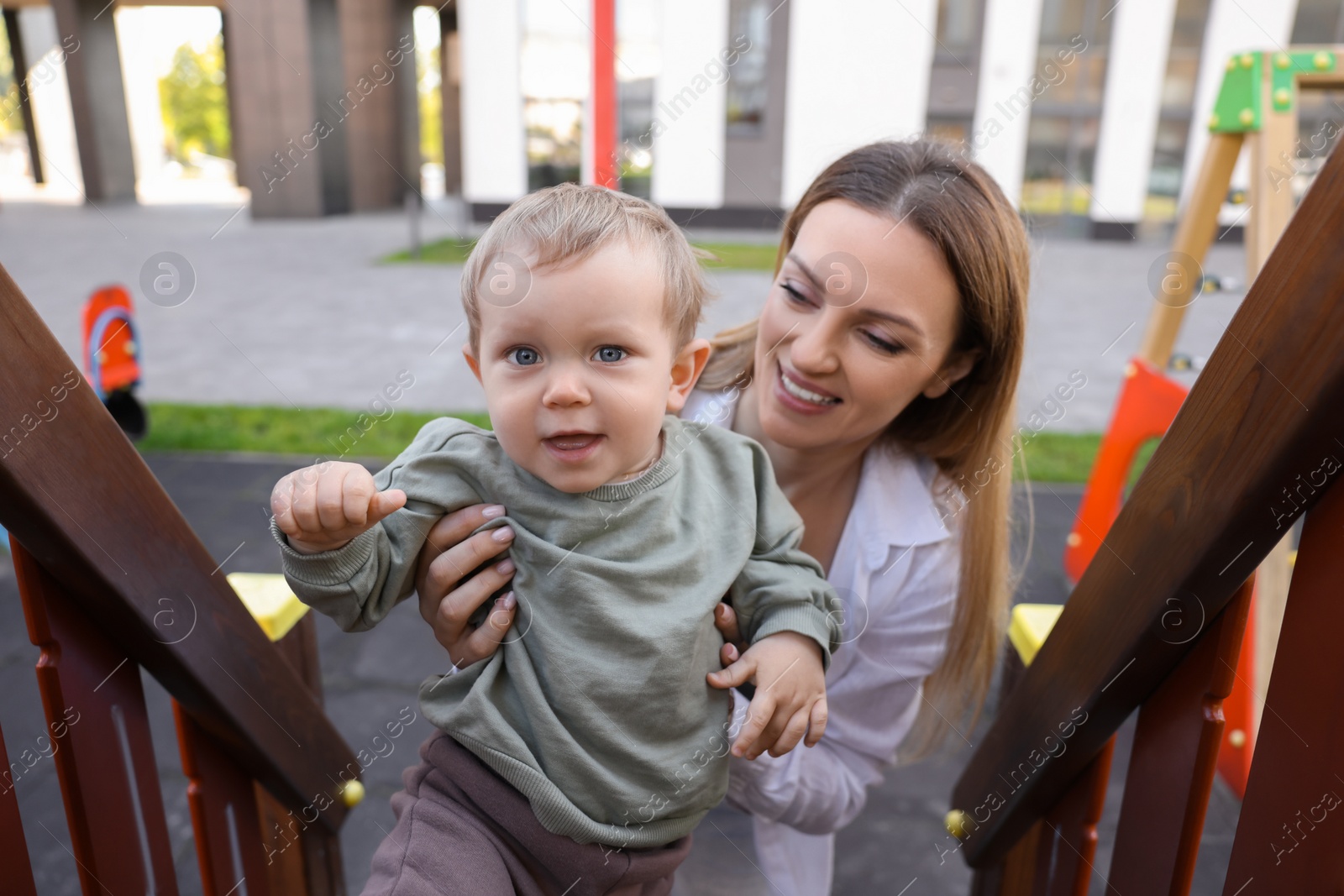 Photo of Happy nanny with cute little boy at playground