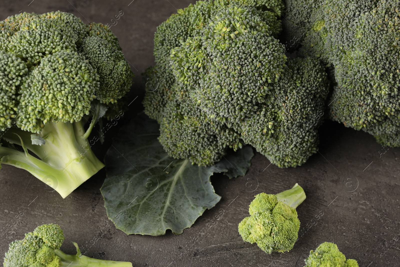 Photo of Fresh raw broccoli on grey table, closeup