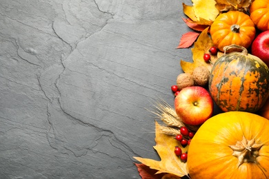 Photo of Flat lay composition with ripe pumpkins and autumn leaves on grey table, space for text. Happy Thanksgiving day