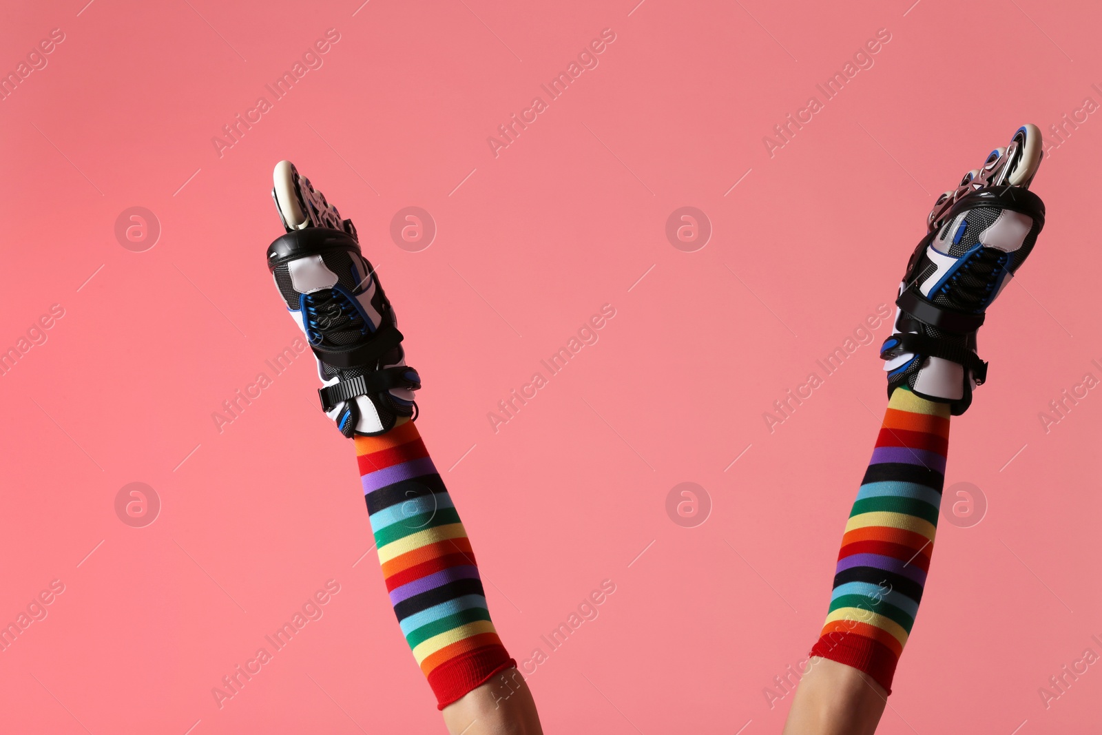 Photo of Woman with roller skates on color background, closeup