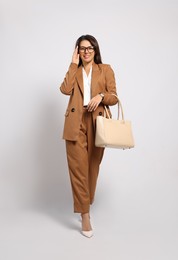 Photo of Young woman with stylish bag on white background