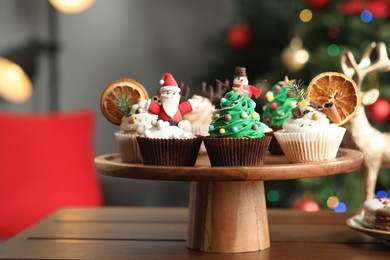 Photo of Many different Christmas cupcakes on wooden table indoors