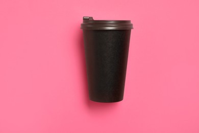 Takeaway paper coffee cup on pink background, top view