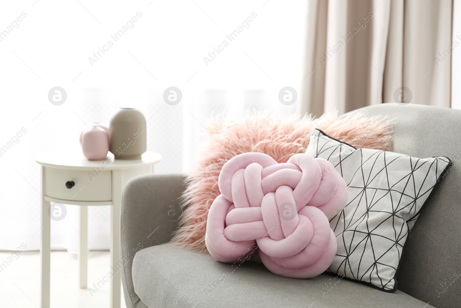 Photo of Different soft pillows on sofa in room. Interior element