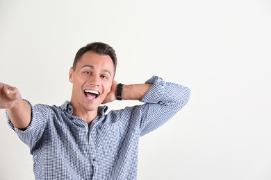 Photo of Laughing man taking selfie on white background. Space for text