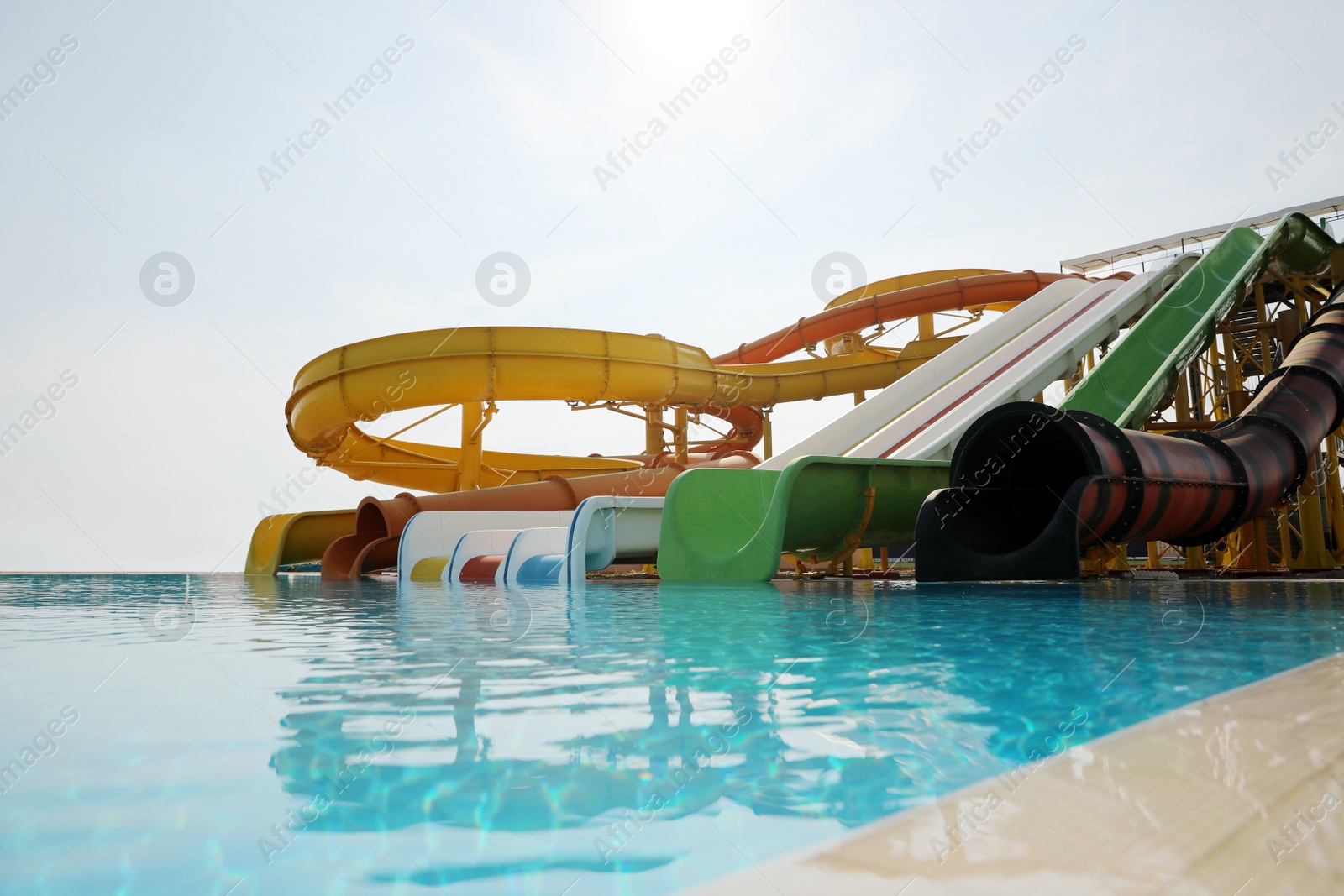 Photo of Beautiful view of water park with colorful slides and swimming pool on sunny day