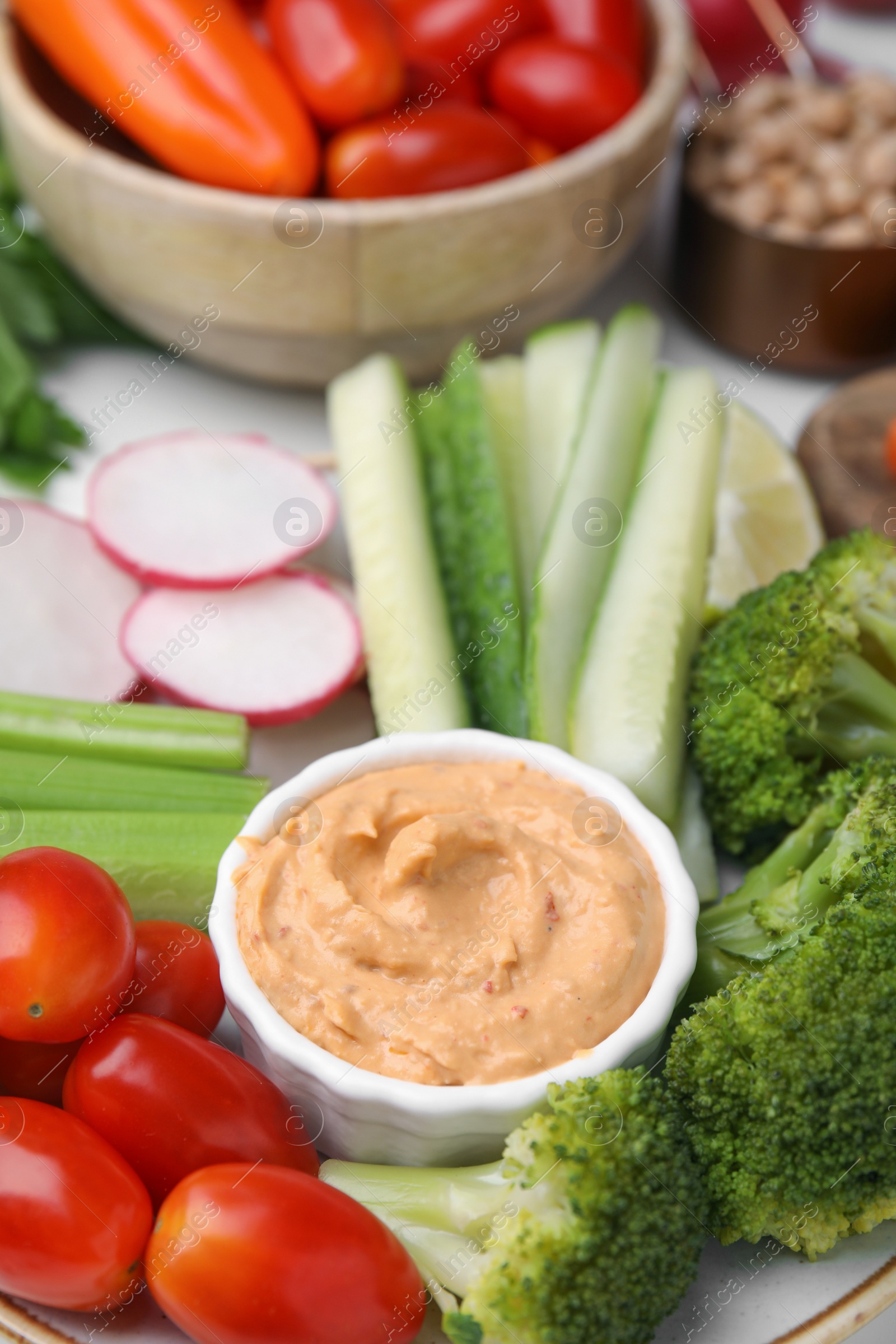 Photo of Plate with delicious hummus and fresh vegetables, closeup