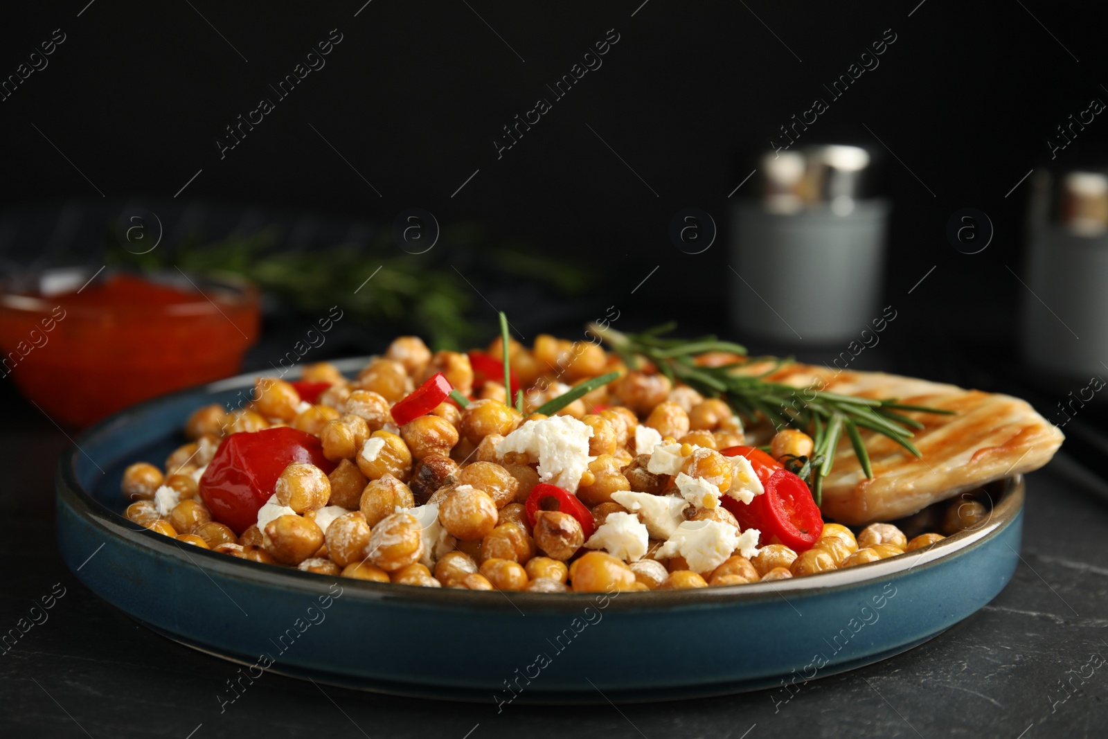 Photo of Delicious fresh chickpea salad on black table
