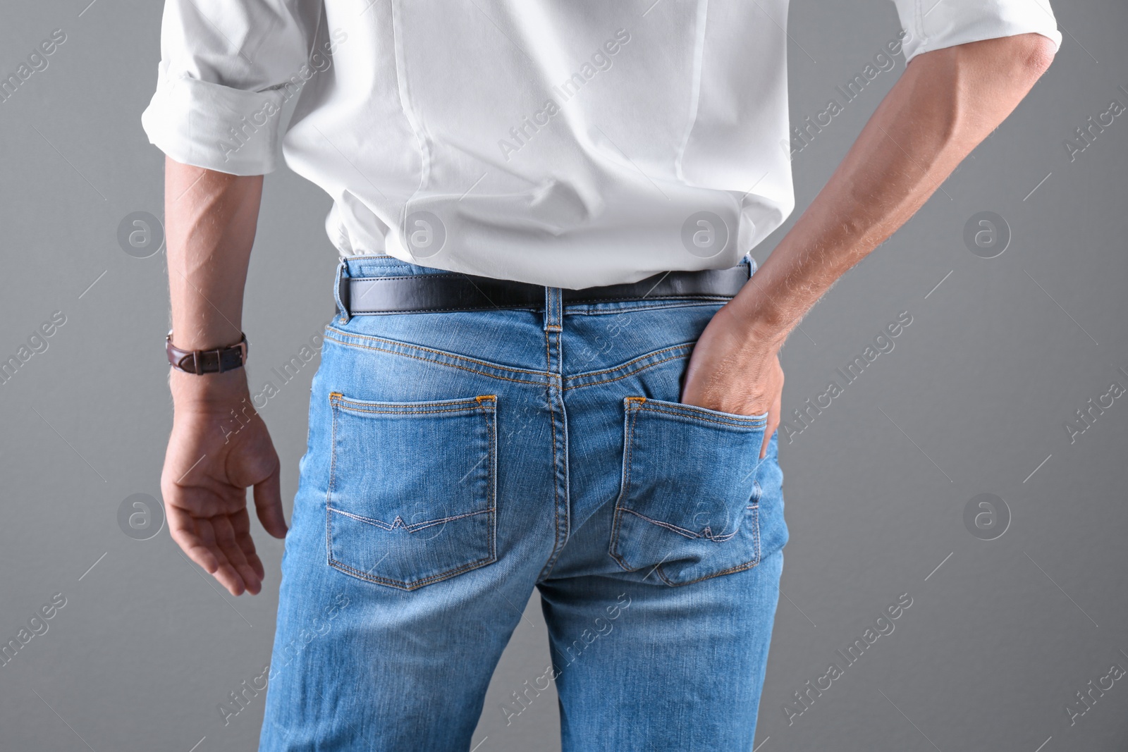 Photo of Man in stylish blue jeans on grey background