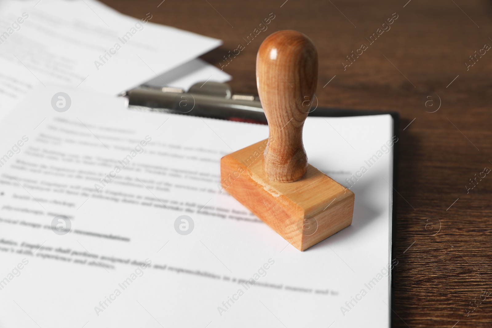 Photo of Documents and stamp on wooden table, closeup. Notary contract