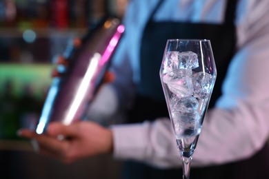 Photo of Bartender making fresh alcoholic cocktail in bar, selective focus