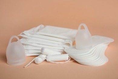 Menstrual pads and other period products on pale orange background