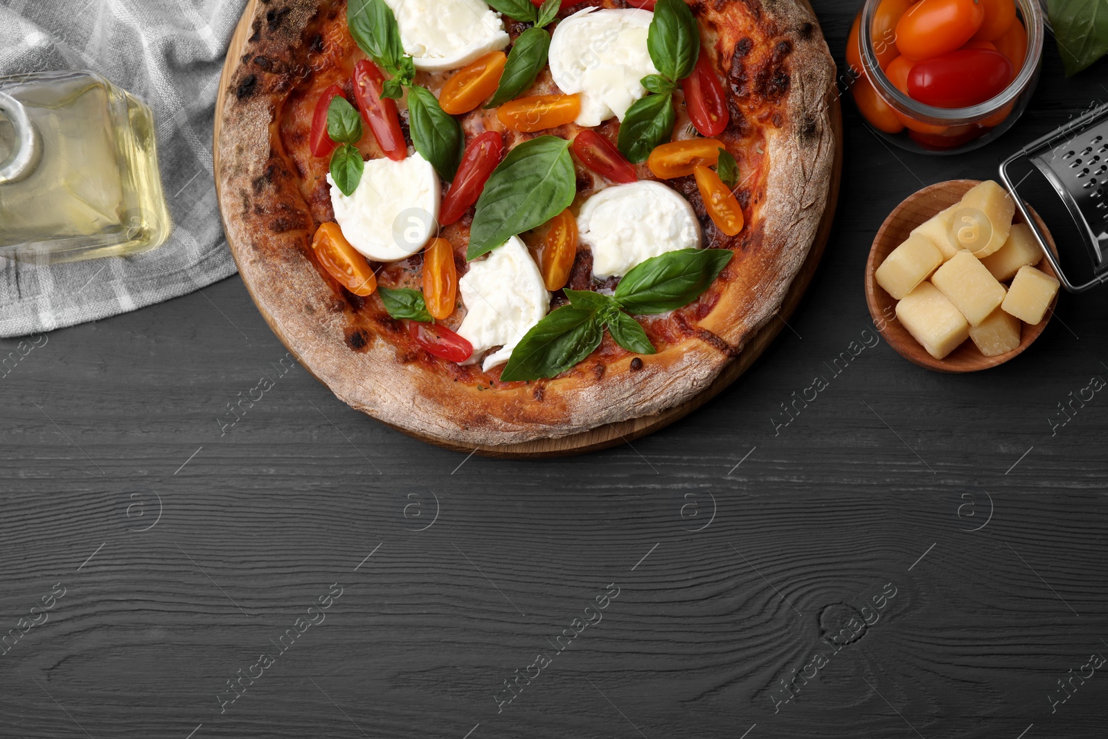 Photo of Delicious pizza with burrata cheese, tomatoes and basil served on grey wooden table, flat lay. Space for text