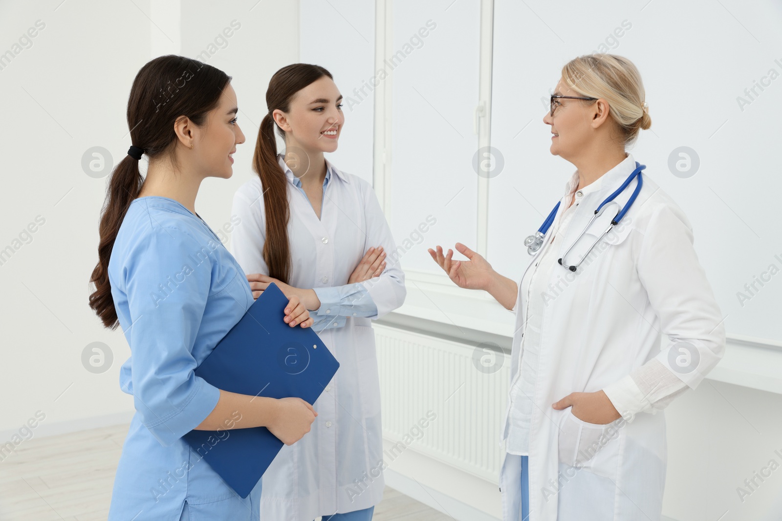 Photo of Medical doctors in uniforms having discussion indoors