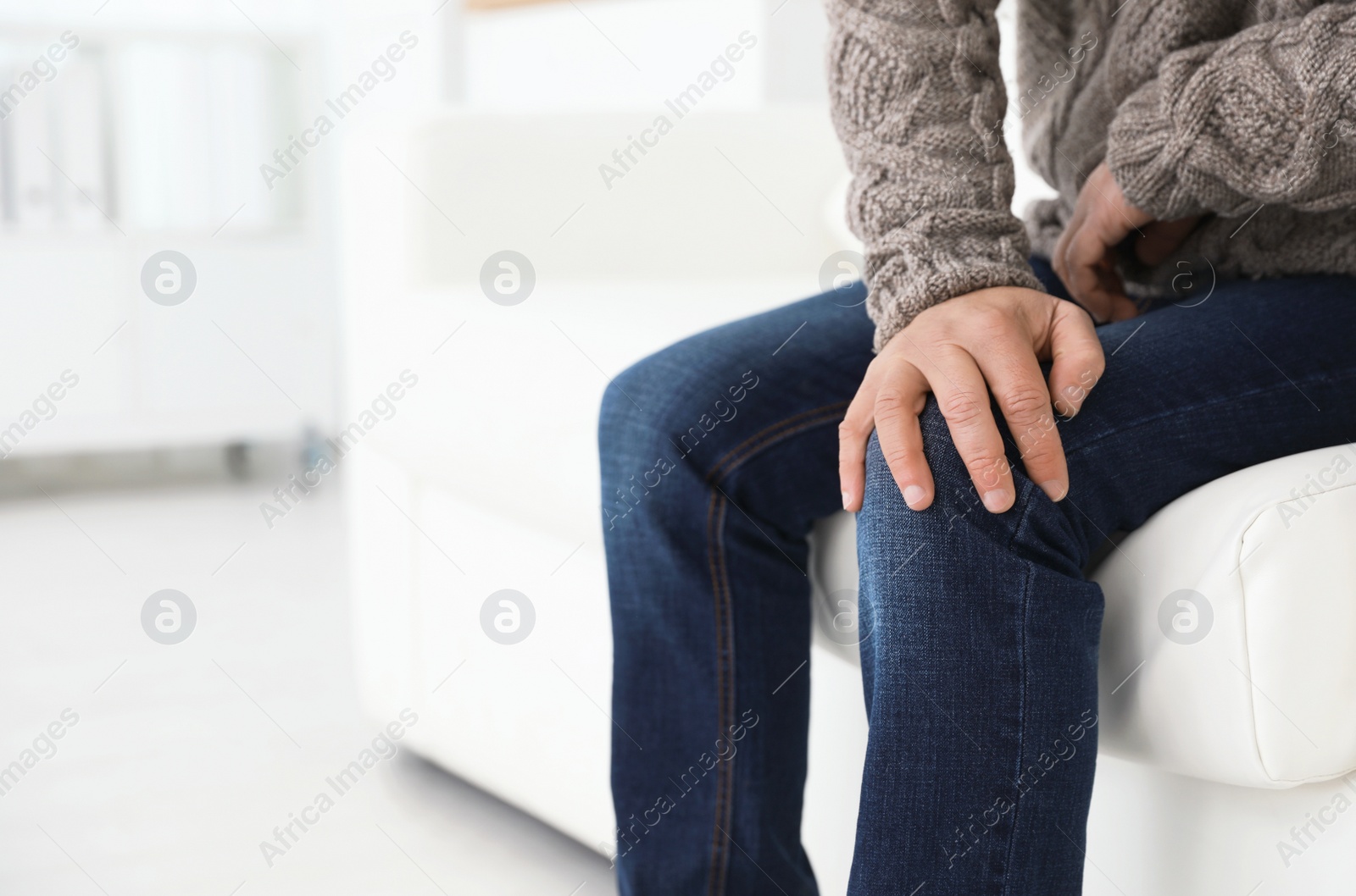 Photo of Mature man suffering from leg pain at home, closeup. Space for text