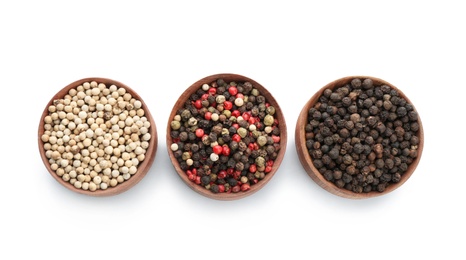 Photo of Bowls with different kinds of pepper grains on white background, top view