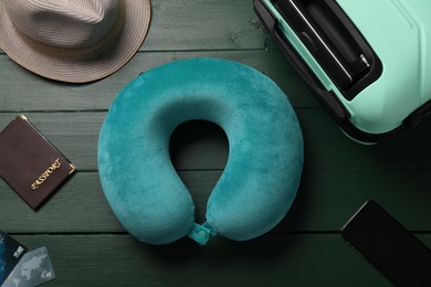 Photo of Flat lay composition with turquoise travel pillow and smartphone on green wooden background