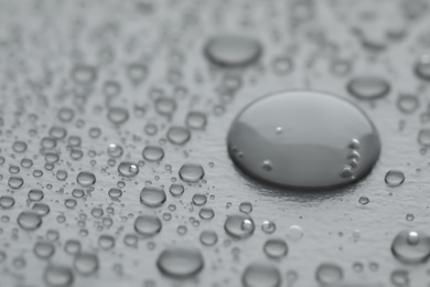 Photo of Water drops on grey background, closeup view