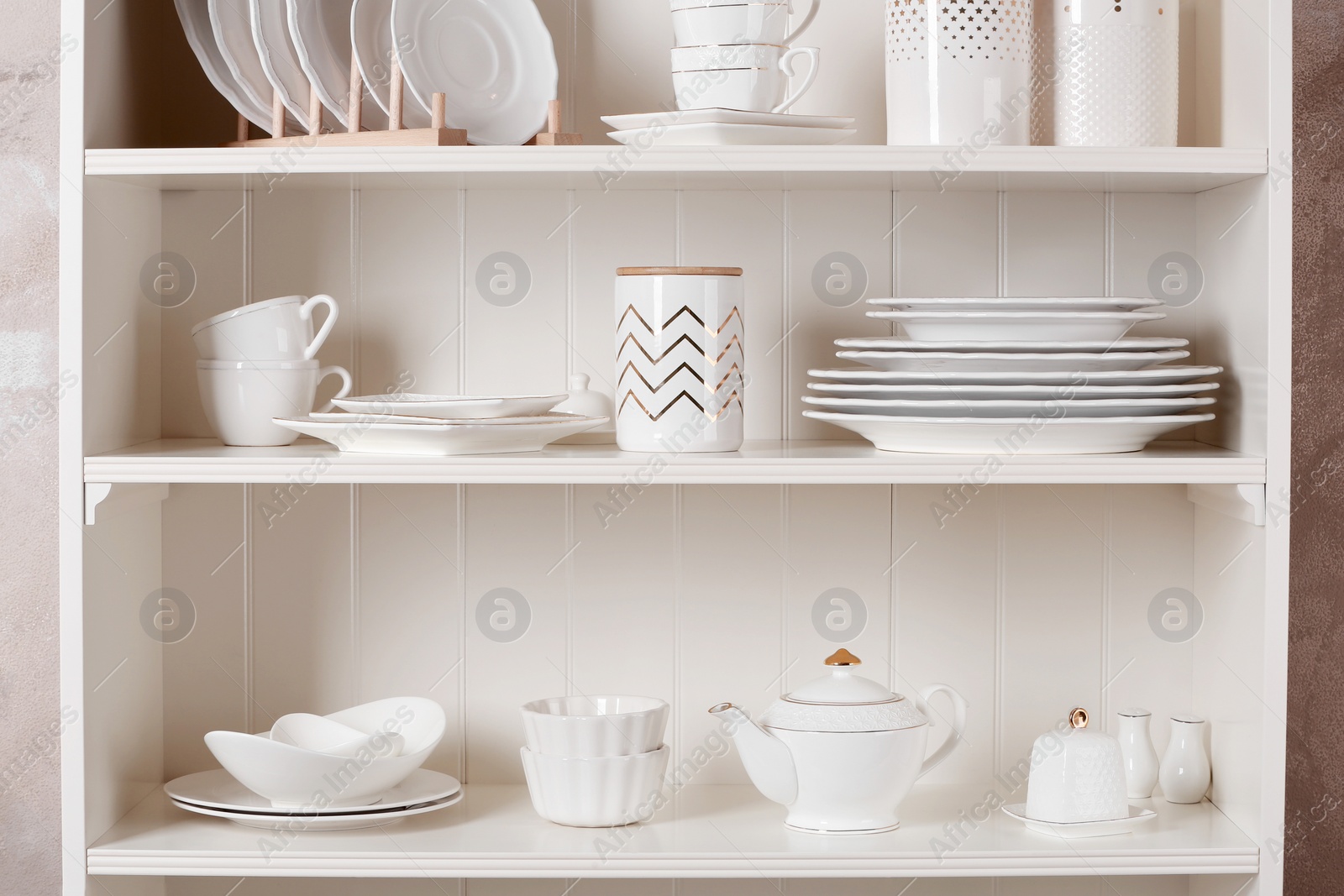 Photo of Stylish storage stand with different ceramic dishware at home