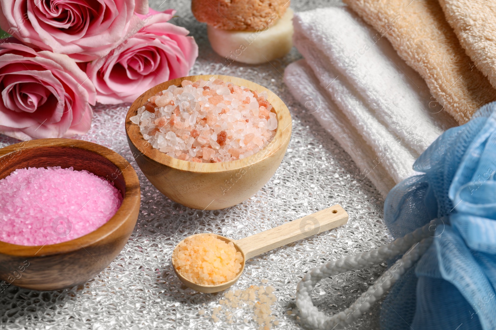 Photo of Natural sea salt and beautiful roses on textured table