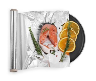 Aluminum foil with raw salmon, orange slices, rosemary and spices isolated on white, top view