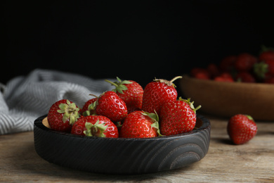 Photo of Delicious ripe strawberries on wooden plate, closeup