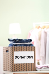 Donation box with clothes on table indoors