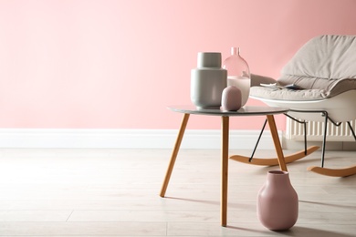 Photo of Beautiful vases in stylish living room interior. Space for text