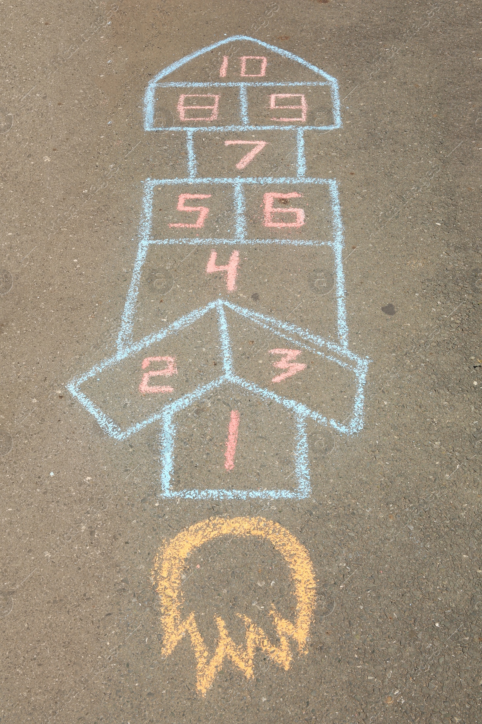 Photo of Hopscotch drawn with colorful chalk on asphalt outdoors