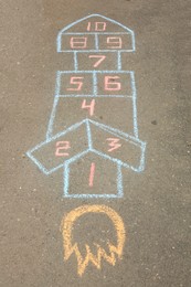 Photo of Hopscotch drawn with colorful chalk on asphalt outdoors