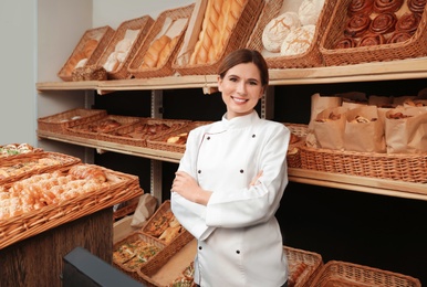 Portrait of professional baker near showcase in store